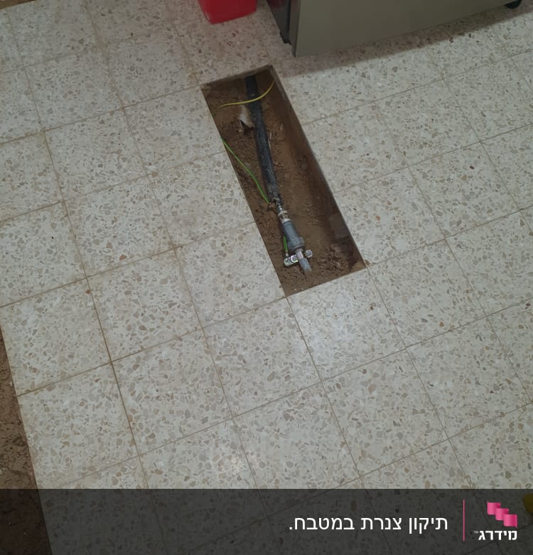 צינור מים חשוף ברצפה עם חיבורי אינסטלציה